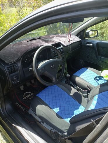 Tünd rəngli Opel Astra Universal avtomobili. Avtomobilin salonu qara