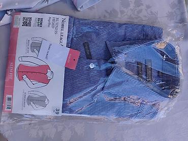 Muška košulja plave boje sa belim prugama, „slim fit“ kroja. Ima na lalafo.rs Muška košulja plave boje sa belim prugama, „slim fit“ kroja. Ima