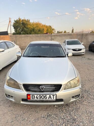 эмблема авто: Серебристый седан Lexus IS 200 с характерной решеткой радиатора и