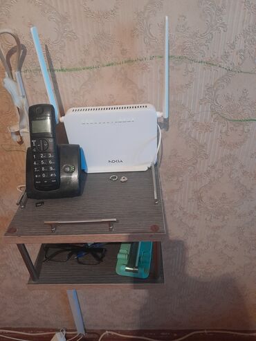 Çəngəllər: Ağ rəngli, iki xarici antenası olan Nokia Wi-Fi router. Cihazın yuxarı