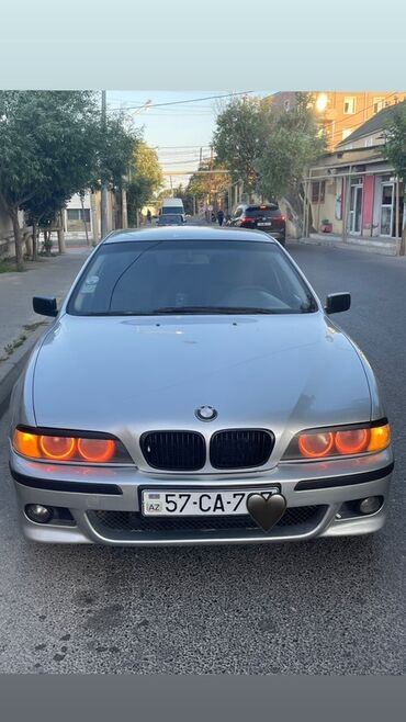Gümüşü rəngdə BMW 5 Series E39 sedan avtomobili. Avtomobilin ön