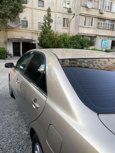 какую машину можно купить за 200 тысяч: Седан Toyota Camry в золотистом цвете, оснащенный тонированными