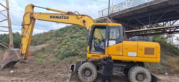 hidromek azerbaycan da ekskavator satisi: Komatsu təkərli ekskavator. Sarı rəngdədir və təkərlər üzərində