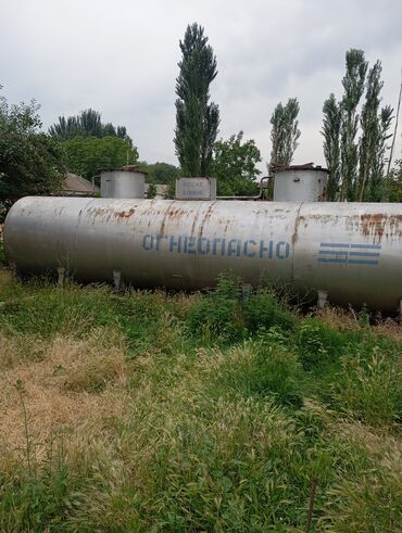 бочки газ: Горизонтальная цистерна серебристого цвета с надписью "Огнеопасно"