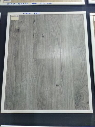 Linoleum: Boz rəngdə ağac naxışlı laminat döşəmə nümunəsi. Bu laminat, müasir və