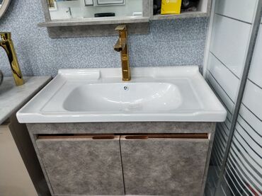 hamam qaplari: Ağ rəngli keramika lavabo, qəhvəyi rəngli dolab ilə birlikdə. Qızılı