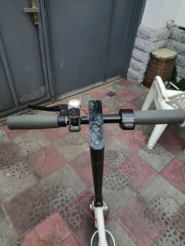 elektrik samokat: Ağ və qara rənglərdə elektrik skuter. Tutacaqlar rahat istifadə üçün