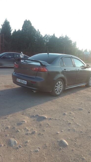 запчасти на митсубиси лансер 9: Седан Mitsubishi Lancer в темно-сером цвете, оснащенный характерным