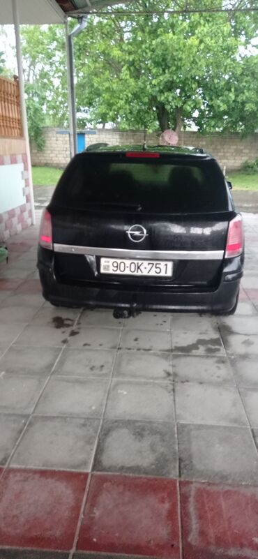 Opel: Qara rəngdə olan Opel Astra universal avtomobili. Avtomobilin ön — 8