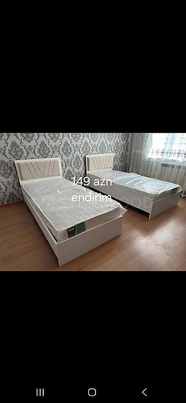 Açıq rəngdə, müasir dizaynlı tək nəfərlik çarpayılar. Yumşaq, yastı