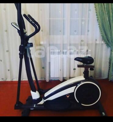 elliptik trenajor: Qara və ağ rənglərdə olan elliptik trenajor. Oturacağı var və evdə