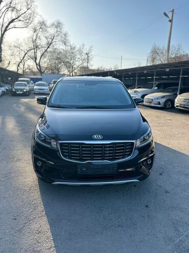 авто кежи: Черный минивэн Kia Carnival. Этот автомобиль предлагает просторный и