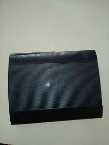 PS3 (Sony PlayStation 3): Qara rəngdə olan PlayStation 3 oyun konsolu, üç ədəd Sony idarəetmə