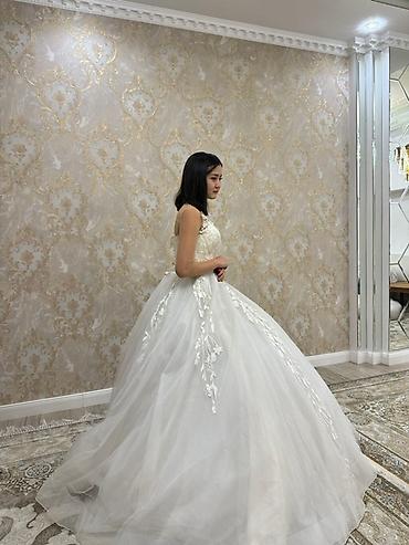 шикарное платье: Белое свадебное платье с пышной юбкой и кружевным верхом. Платье имеет — 4