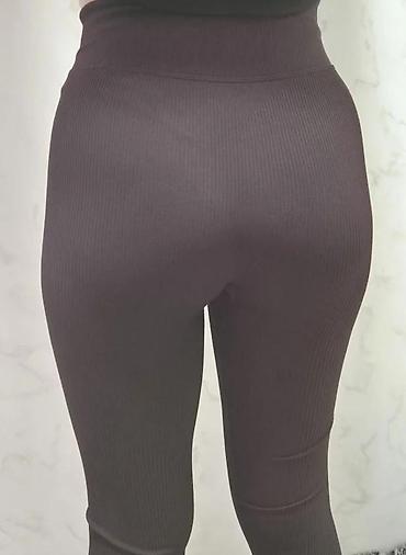 Helanke, biciklistički šortsevi: Ženske helanke tamne boje sa rebrastom teksturom. Karakteriše ih visok — 6