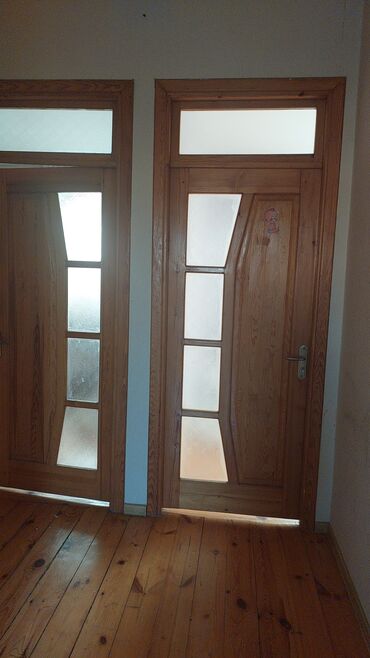 Bunker qapıları: Tutqun şüşə panelləri və unikal geometrik dizaynı olan taxta daxili