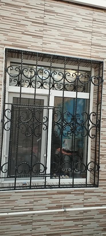 Barmaqlıqlar: Qara rəngli, dekorativ naxışlı dəmir pəncərə barmaqlıqları. Bu — 1