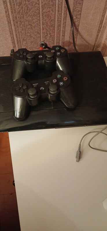 PS3 (Sony PlayStation 3): PlayStation 3 oyun konsolu və iki ədəd qara rəngli idarəetmə pultu