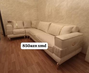 divan koşesi: Künc divan – krem rəngli, yumşaq parça üzlü. L‑şəkilli konstruksiya — 1