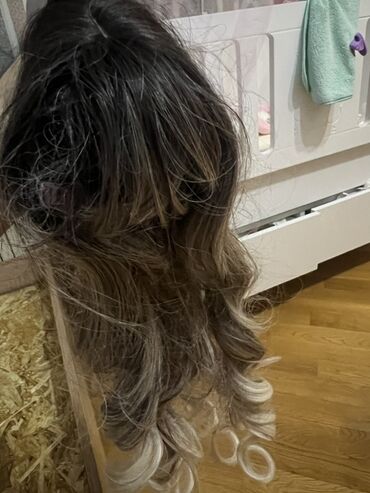 Uzun, buruq saçlı, tünd köklərdən açığa doğru rəng keçidi olan qadın