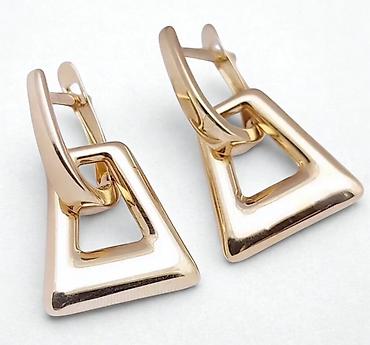 Серьги: Пара элегантных золотистых сережек с английским замком. Каждая сережка — 2