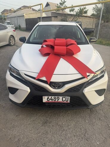 автолюлька ош: Toyota Camry, белый седан с выразительной передней оптикой и фирменной