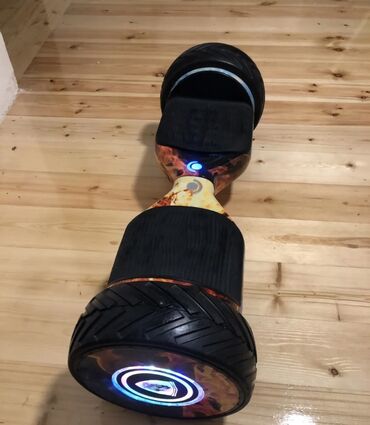 hoverboard qiymətləri: Yan tərəflərində alov naxışları olan qara rəngli hoverboard. Təkərləri
