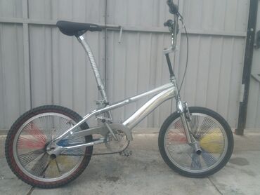 дом на калеса: Велосипед BMX с хромированной рамой и цветными спицами. Оснащен черным