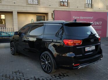 ижара машине: Минивэн Kia Carnival черного цвета, оснащенный черными легкосплавными