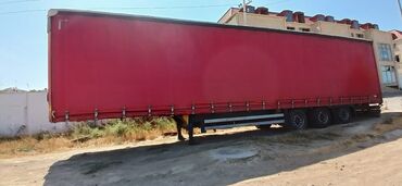 DHL loqosu ilə qırmızı rəngdə yük qoşqusu. Bu qoşqu yükdaşımalar üçün