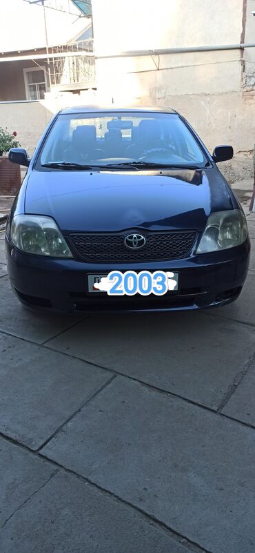 крыло нексия 1: Темно-синий седан Toyota Corolla 2003 года выпуска. Автомобиль оснащен