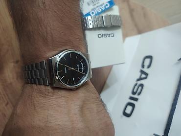 casio saatlari: CASIO brendinin gümüşü rəngli metal kəmərli və qara siferblatlı kişi — 2