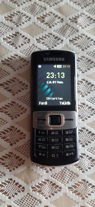 Samsung markalı, qara rəngli düyməli mobil telefon. Bu mobil telefon