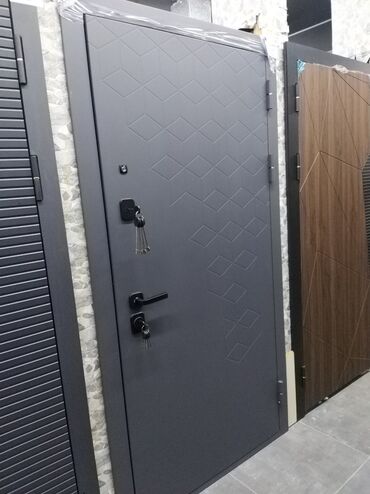 qapi alisi: Ziqzaq naxışlı boz rəngdə metal giriş qapısı. Qapının üzərindəki romb