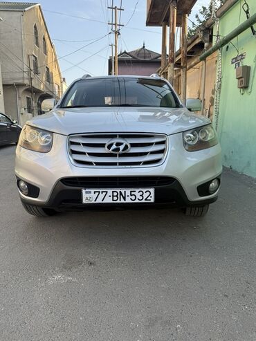 Gümüşü rəngdə, dördtəkərli Hyundai Santa Fe SUV. Avtomobil geniş ön