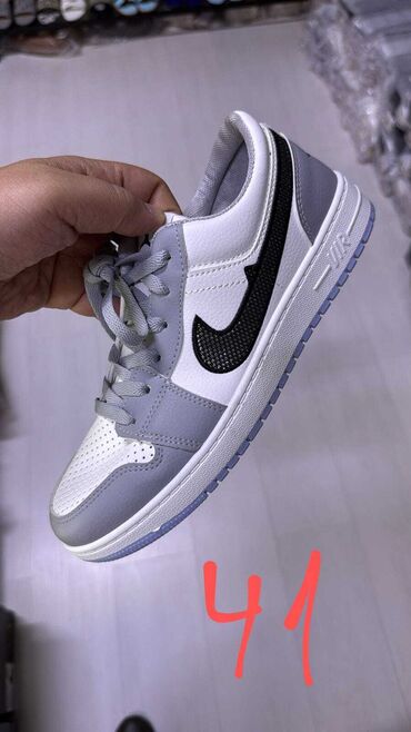 Krasofkalar və idman ayaqqabıları: Ağ və boz rənglərdə Nike idman ayaqqabısı. Qara rəngdə Nike loqosu ilə