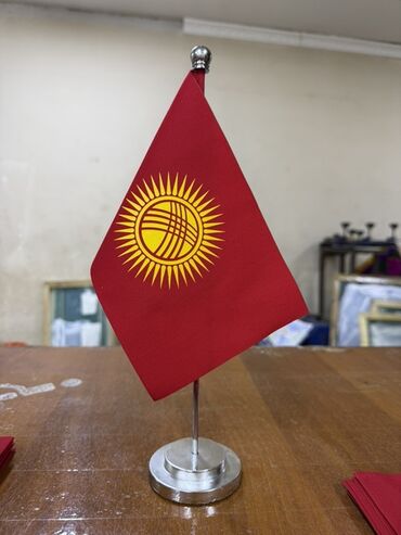 кыргыз кийимдери: Настольный флаг Кыргызстана с ярким красным полотном и изображением