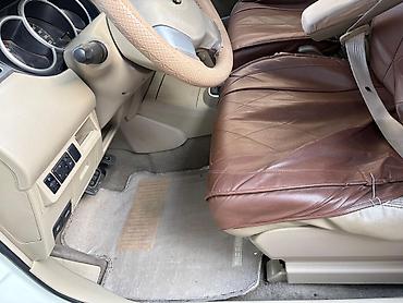 nisan note: Ağ rəngli Nissan Tiida sedan. Avtomobilin salonu açıq bej tonlarda — 1