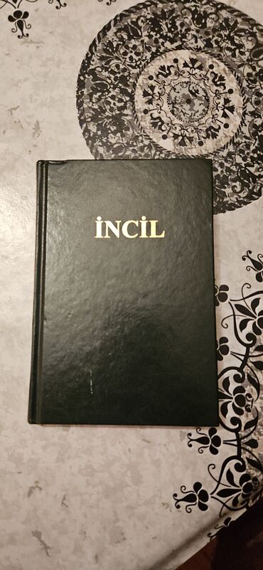 Yaşıl rəngli sərt üzlüklü dini kitab. Kitabın üz qabığında qızılı