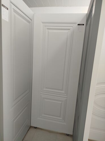 Ağ rəngdə, müasir üslubda, dekorativ panel naxışlı qapı. Bu qapı iki