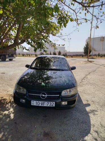Другой транспорт: Tünd yaşıl rəngli dördqapılı Opel Omega avtomobili. Avtomobilin salonu