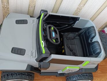 Böyük təkərləri və sağlam gövdəsi olan boz rəngli elektrikli uşaq