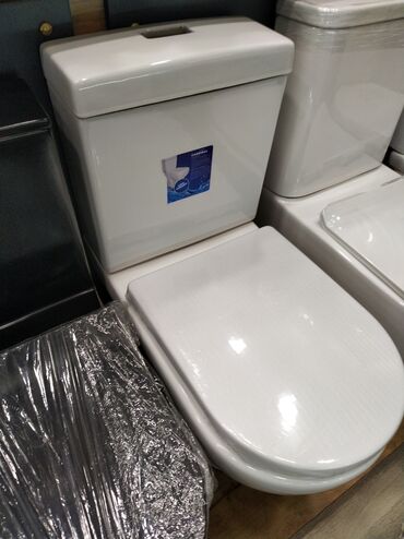 Hamam üçün aksessuarlar: Ağ rəngdə, müasir dizaynlı unitaz. Bu unitaz, həm evdə, həm də ofisdə