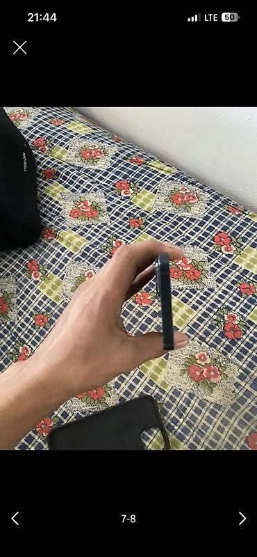 Смартфон с плоскими гранями и темно‑синим/черным корпусом. На левом