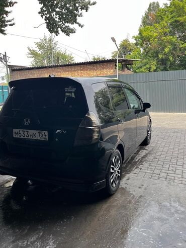 камера для шины: Черный хэтчбек Honda Fit с тонированными задними фарами и спойлером