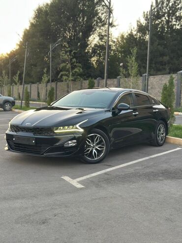 машина кж базар коргон: Элегантный черный седан Kia K5, припаркованный на асфальтированной