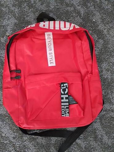 Crveni ranac sa natpisima “BE YOUR STYLE” i “LIMITED EDITION”. -