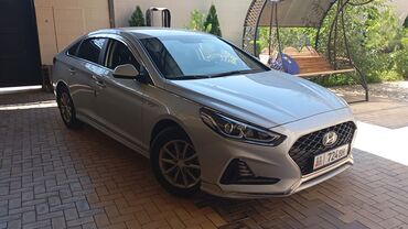 граната на матиз: Современный седан Hyundai Sonata серебристого цвета, представленный