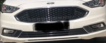 Ford: Ağ rəngdə olan Ford markalı avtomobilin ön hissəsi. Zavod ustde