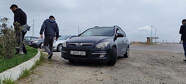 i30: Hyundai i30 CW, qara rəngli universal kuzov. Xüsusiyyətlər: - Kuzov — 9